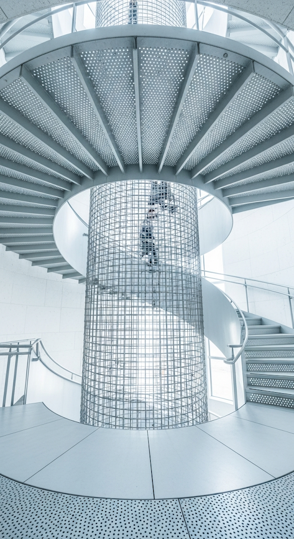 Abstract View of Modern Metal Spiral Staircase with Central Wire Mesh Cage