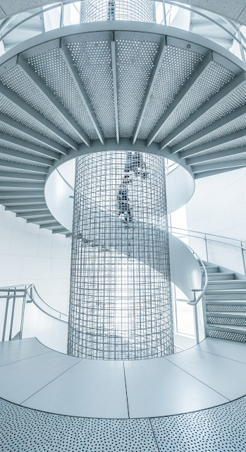 Abstract View of Modern Metal Spiral Staircase with Central Wire Mesh Cage - Free mobile Wallpaper