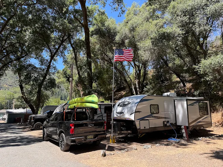 RV site with an American flag and a kayak on a pickup truck