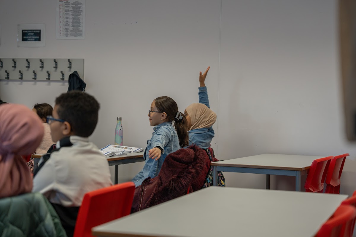 Girl raising her hand to answer a question