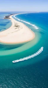 Speedboat Wake Over Turquoise Waters by White Sandbar