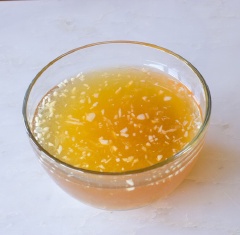 Cho ức gà ngược trở lại nồi, cho muối và tiêu vào nấu chín hoàn toàn để thịt gà đậm đà hơn. Vớt ra ngoài để ráo. Chuẩn bị nước trộn gỏi, chanh vắt lấy nước cốt. Đường trắng, tỏi băm pha với nước cho tan đường, sau đó cho nước cốt chanh vào khuấy tan, kế tiếp là nước mắm.