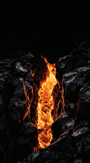 Glowing molten orange lava pulsing through sharp black obsidian rock fissures at night.