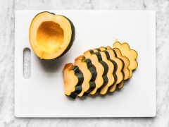 Mở trước lò nướng ở 190 độ C. Bí đỏ rửa thật sạch lớp vỏ bên ngoài, sau đó cẩn thận cắt bí làm đôi, nạo bỏ hạt và cắt thành từng miếng dày cỡ 1cm. Làm nước ướp: cho 1 muỗng dầu olive, 1 muỗng syrup cây phong, 1/2 muỗng bột ớt paprika, 1/4 muỗng muối và trộn đều lên trong chén.