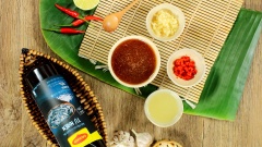 Bắc nồi hoặc chảo lên bếp, cho vào 4 muỗng canh nước mắm Maggi, 4 muỗng canh nước lọc, 80gr đường trắng rồi đun sôi liu riu đến khi hỗn hợp nước mắt keo sệt lại thì tắt bếp, để nguội. Chuẩn bị sẵn 10gr tỏi băm, 5gr ớt băm và 30ml nước cốt chanh, cho tất cả vào chén nước mắm khuấy đều cho tất cả hòa quyện.