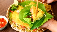 Dọn bánh xèo ra mâm cùng với nước mắm và thật nhiều rau rồi thưởng thức thôi nào. Bánh xèo với lớp vỏ ngoài giòn rụm béo vị nước cốt dừa, bọc lấy nhân tôm thịt cùng giá đỗ đậu xanh, giòn bùi mặn ngọt đủ vị, cuốn chung với các loại sau sống rồi chấm vào nước mắm chua ngọt, nghe thôi cũng đã thấy thèm lắm rồi. Vào những ngày trời mưa rả rích mà có dĩa bánh xèo cốt dừa tôm thịt để cả nhà quây quần bên nhau thì tuyệt vời biết mấy đúng không?