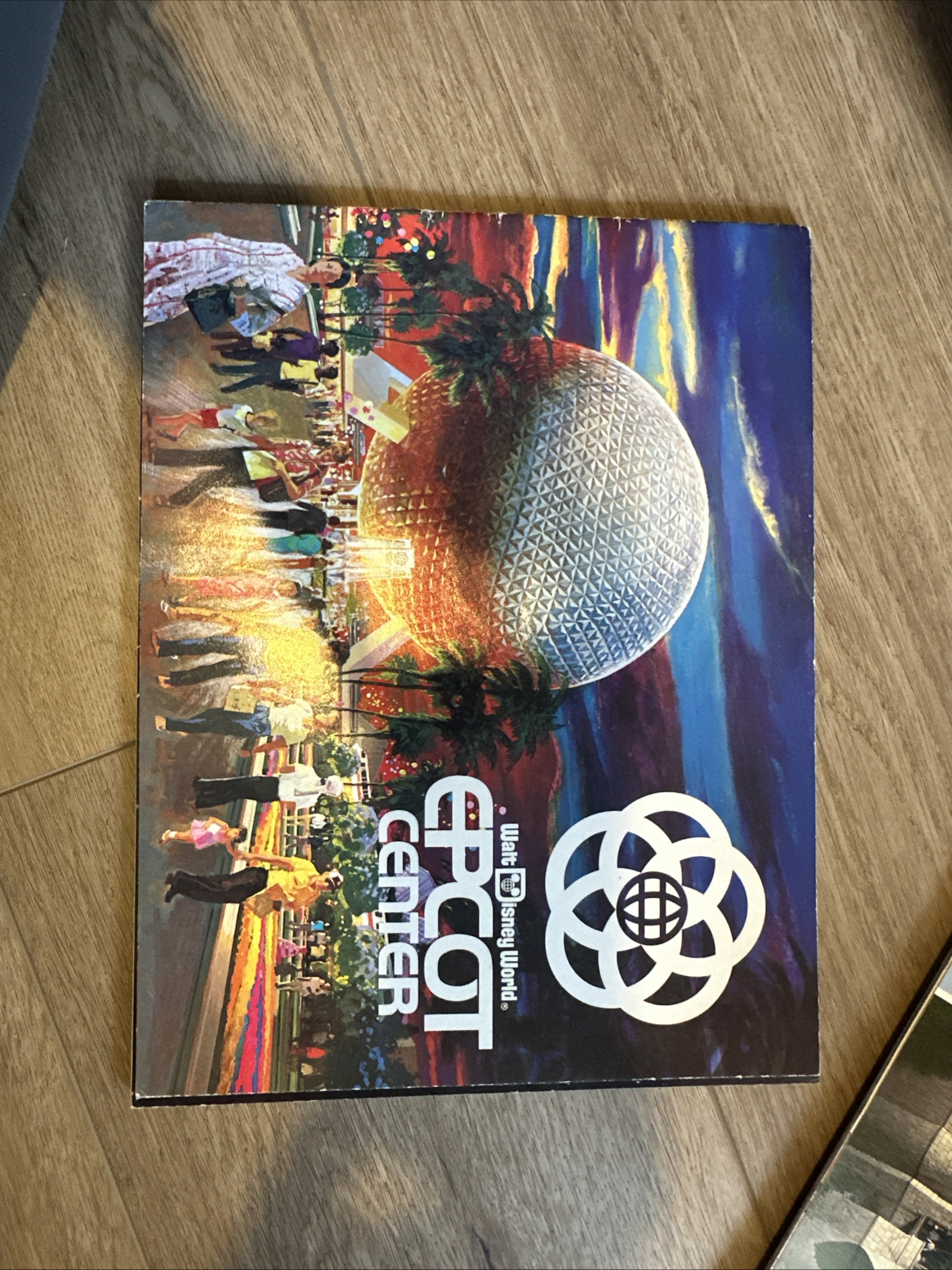 Large-format EPCOT Center opening-era souvenir program with Spaceship Earth at sunset cover illustration and original five-ring logo, circa 1982