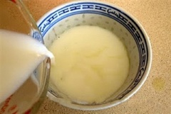 Hòa sữa nguyên kem và đường trong một cốc lớn rồi cho sữa vào hâm nóng đến khoảng 80-90 độ C hoặc các bạn cũng có thể cho vào vi sóng trong 1-2 phút cũng được. Sau đó, lấy sữa ra rồi cho vào chén nước ép gừng, khuấy đều và chờ khoảng 10 phút cho sữa đông lại nhé!