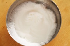 Để làm cho eggnog có độ bông mịn, bạn đánh bông cứng phần lòng trắng trứng. Dùng máy đánh trứng đánh bông 2 lòng trắng trứng cùng 60g đường để làm kem.