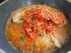 Bắc chảo lên bếp, cho vào 3 muỗng canh dầu, chờ dầu nóng cho cá vào chiên với lửa vừa. Cá vàng hai mặt thì đổ hết chén gia vị và cà chua băm vào đậy nắp rim lửa thấp cho đến khi sốt sánh cá thấm gia vị, nêm nếm lại cho vừa ăn là tắt bếp.