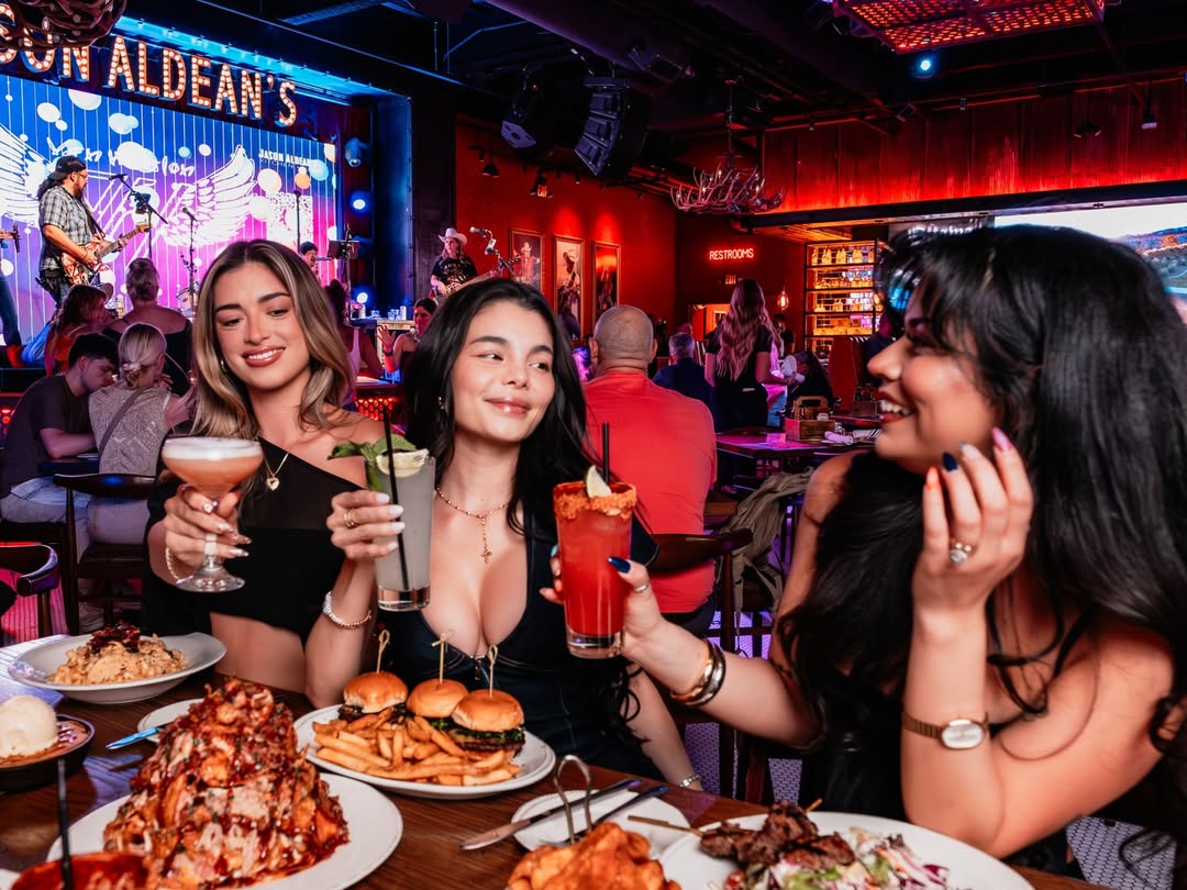 Interior view of Jason Aldean's with rustic decor, wooden tables, and live music stage.