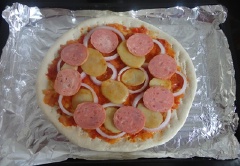 Phết một lớp nước sốt cà chua lên bề mặt đế bánh pizza sau đó lần lượt xếp hành tây, thịt nguội, khoai tây lên trên. Sau đó xếp thịt gà và phô mai được rắc lên trên cùng.