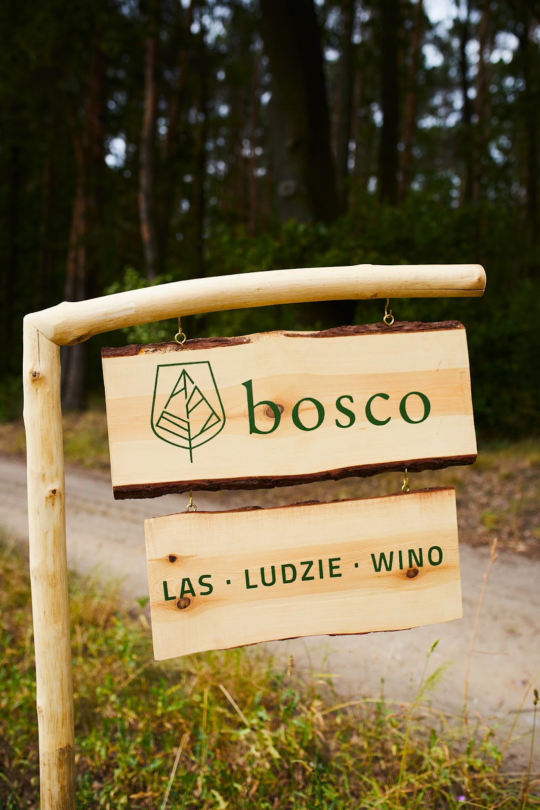 Szyld bosco: las · ludzie · wino — miejsce spotkań
