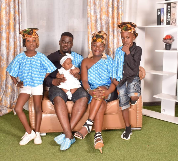 Medgclay Salano (holding baby) with his wife and children at their home in Kakamega county. He is now a father of four despite undergoing a vasectomy