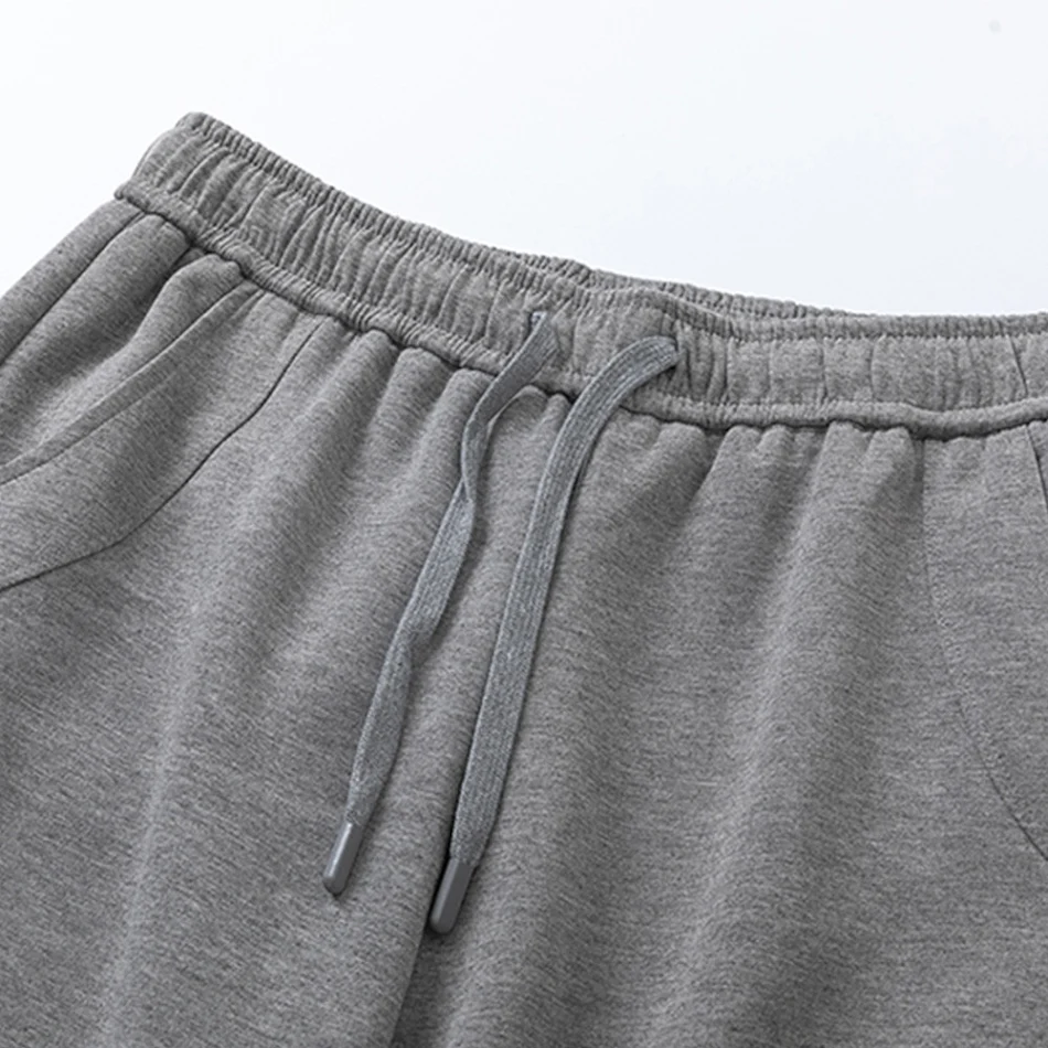 Pantalones deportivos holgados para hombre estilo americano, costuras y color sólido. Comodidad y libertad de movimiento para tus deportes.