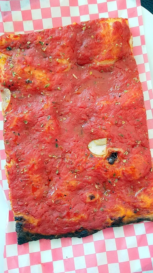 Roman Candle Baking Company offers a Roman style Pizza Bianca- here is Pomodoro with Tomato, oregano, xvoo, sea salt