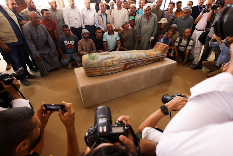Mostafa Waziri, secretary-general of Egypt's Supreme Council of Antiquities takes a souvenir picture with the official archaeologists' team in front of a sarcophagus found at the newly discovered site where two embalming workshops for humans and animals along with two tombs and a collection of artefacts were also found, near Egypt's Saqqara necropolis, in Giza, Egypt May 27, 2023.