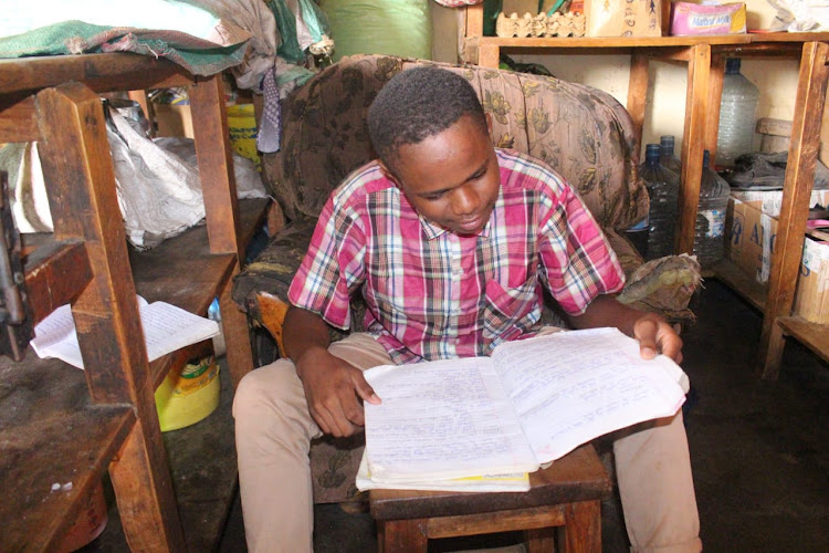 Daniel Mutuku, a form four candidate studies from his home in Mwingi town