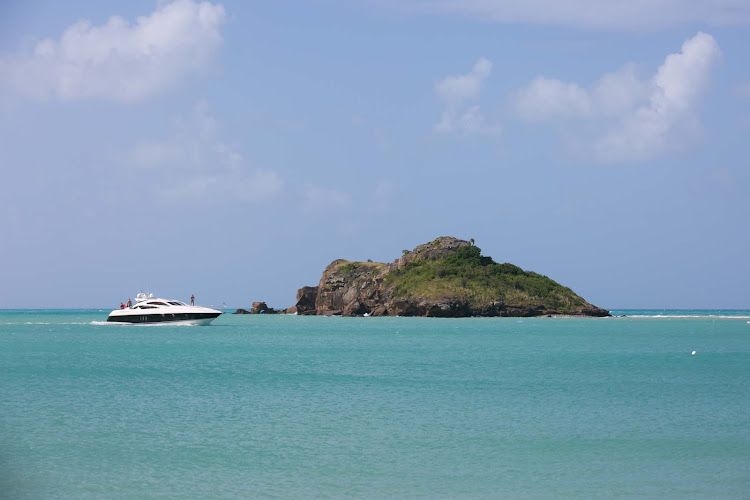 A pleasure boat passes a rock outcropping in Antigua. 