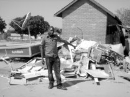 BOMBED: Sowetan journalist Masoka Dube pointing to the damaged ATM in Marite, Mpumalanga. Pic. Riot Hlatshwayo. 22/08/07. © Sowetan.