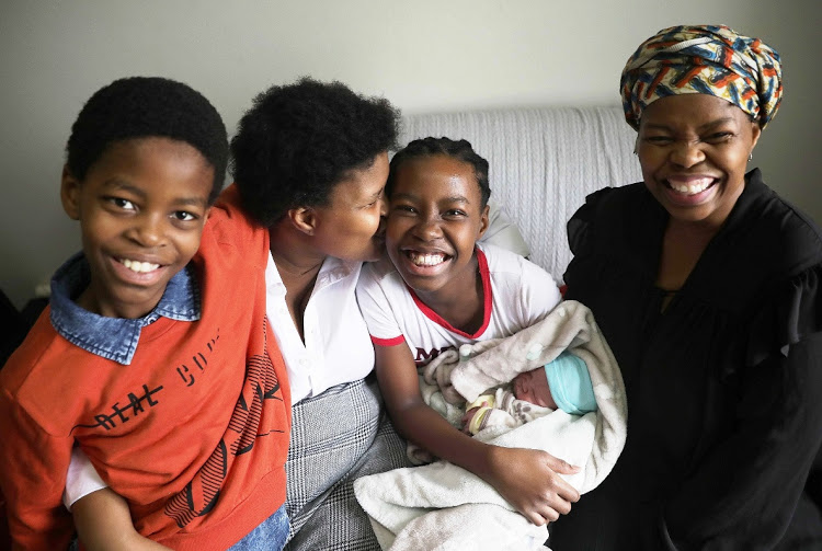 Thandi Ndlebe, right, delivered her sister Vuyolwethu Manhica's son, Mthombo, with the help of instructions from a first aid book found by her son Moleko, 10, and read out by her daughter, Busisiwe, 12.