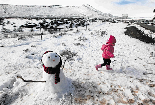 Three-year-old Carla Bosman of Cape Town runs past a snowman outside Fraserburg in the Northern Cape. South Africa experienced freezing temperatures in 2013, with winter floods reported in Knysna and snow in other places.