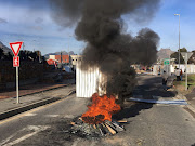 A bonfire burns in front of temporary structures from the Imizamo Yethu relocation camp block in Hout Bay Road. File photo.