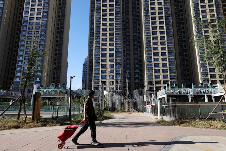 A man pulls a cart past residential buildings at an Evergrande residential complex in Beijing, China. Picture: REUTERS