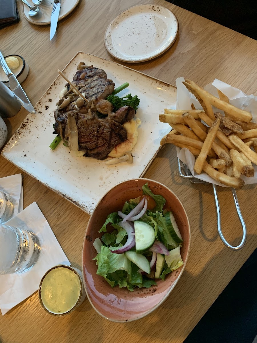 Ribeye with garlic mashed potatoes, broccolini, and wild mushrooms, plus a side salad and fries! All prepared safely