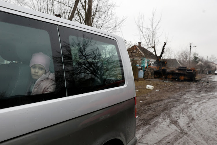 A girl looks out through a window of a van, as Russia's attack on Ukraine continues, in the village of Nova Basan, in Chernihiv region.