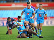 Lizo Gqoboka of the Vodacom Blue Bulls is tackled by Billy Meakes of Rebels during the Super Rugby match at Loftus Versfeld Stadium.