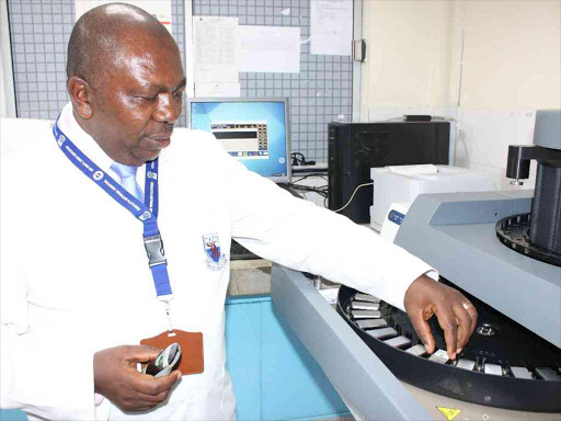 KNH Deputy Director Laboratory Services Andrew K. Gachii demonstrating how the Immuno Histo Chemistry (IHC), a Cancer-screening machine operates at Kenyatta National Hospital on August 9,2016. The machine can support 30 slides at ago. Photo/ Isabel Wanjui.