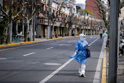 A worker in a protective suit keeps watch on a street as the second stage of a two-stage lockdown to curb the spread of Covid-19 begins in Shanghai, China, on April 1 2022. 