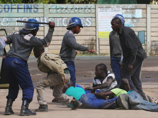 Riot police detain residents of Epworth suburb after a protest by taxi drivers turned violent in Harare, Zimbabwe, July 4, 2016. On Thursday, a campaign against President Robert Mugabe started by a twitter hashtag spiraled into street protests. Photo/ REUTERS