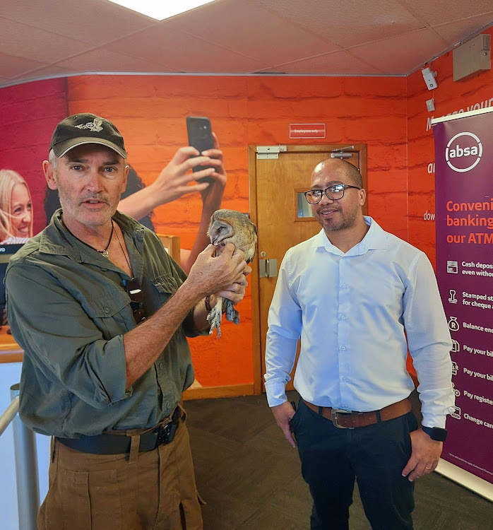 The Owl Rescue Centre's Brendan Murray with the predator at the Absa branch. Murray and the owl centre intervened to ensure the creature's safety.