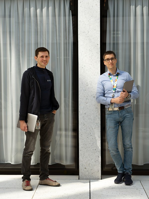 Les deux Googlers Jeroen Kemperman et Tadek Pietraszek sont devant un mur et sourient à la caméra.