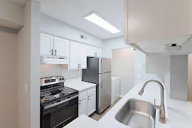 Kitchen with light color cabinetry, stainless steel appliances, and a spacious countertop. Bright and inviting space.