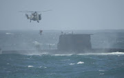 A Super Lynx helicopter hovers above the submarine during the training exercise off Kommetjie. File photo.