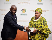 Justice Sandile Ngcobo presents the Section 89 report to The Speaker of Parliament Nosiviwe Mapisa-Nqakula.