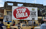 This file picture dated November 7, 2014 shows people walking past a billboard reading 