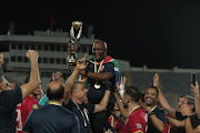 Al Ahly's South African coach Pitso Mosimane is hoisted in the air by players and team staff carrying the coveted Caf Champions League trophy.