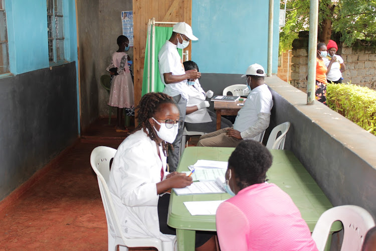 Medics offering health services during a medical camp at Kambirwa dispensary.