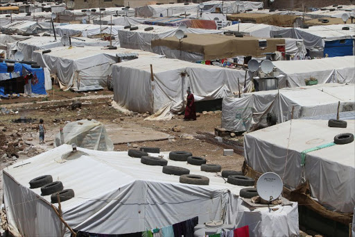 A Syrian refugee woman walks in a makeshift refugee camp in the eastern Lebanese town of Dalhamiyah on May 30, 2014. File photo