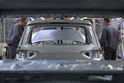 Employees attach an engine hood to a Volkswagen Tiguan compact crossover vehicle in the bodyshop at the Volkswagen AG automobile factory in Wolfsburg, Germany. This plant is expected to reopen on April 20, 2020. 