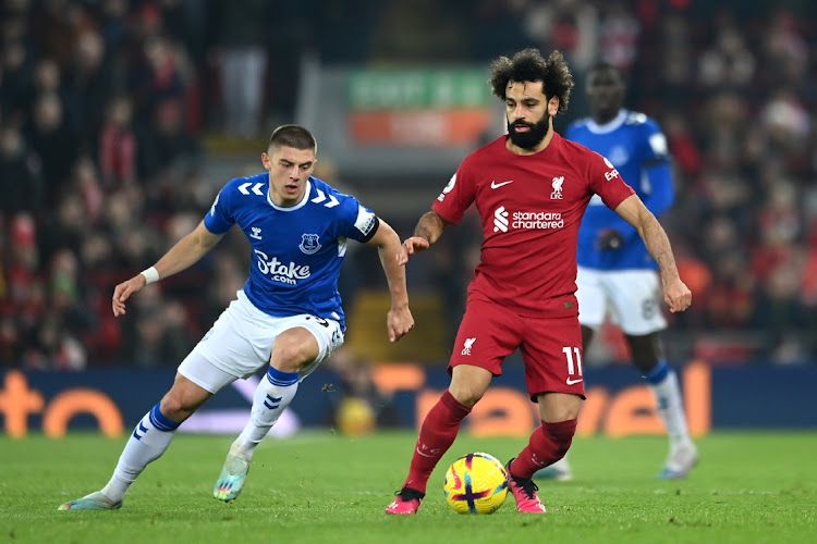 Mohamed Salah of Liverpool is challenged by Vitaliy Mykolenko of Everton during the Premier League match between Liverpool FC and Everton FC at Anfield on February 13, 2023 in Liverpool, England.