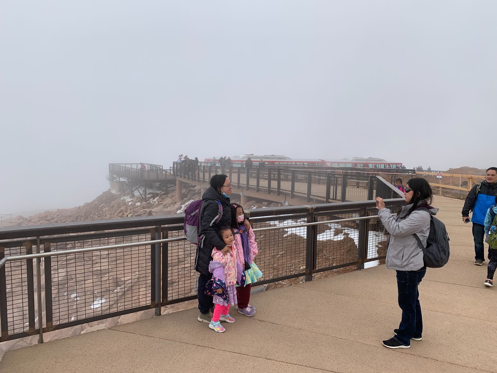 Pikes Peak Summit complex visitors pose for a picture on one of the PermaTrak boardwalks