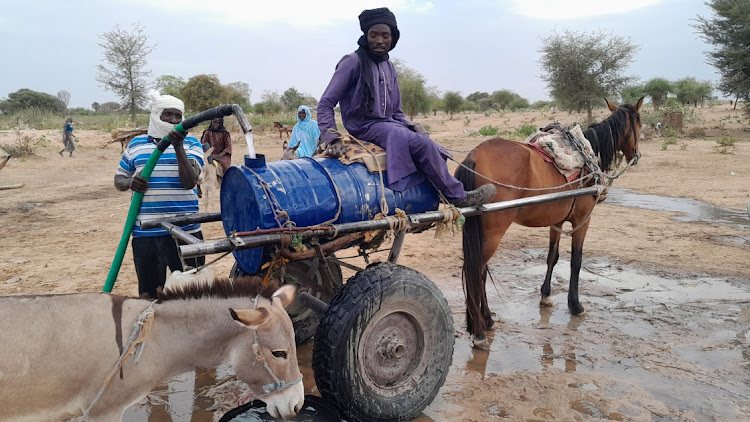 Mahamat Bechir Abdallah, a Sudanese refugee who fled the violence in his country, fills a container as he sells water to the other refugees near the border between Sudan and Chad, in Koufroun, Chad, on May 1 2023.