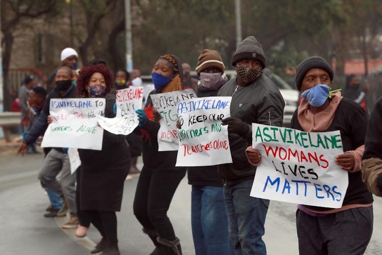 Asivikelane supporters sing revolutionary songs and hold messages raising awareness for issues including gender-based violence and police brutality.