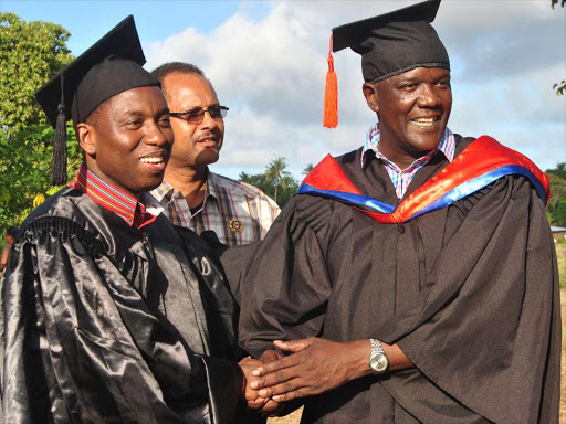 CS Dan Kazungu after graduating with a Masters in Arts and Foreign Policy degree from Moi University with MP Gideon Mung’aro who graduated with a degree in HR Management on December 20, 2015 /ALPHONCE GARI