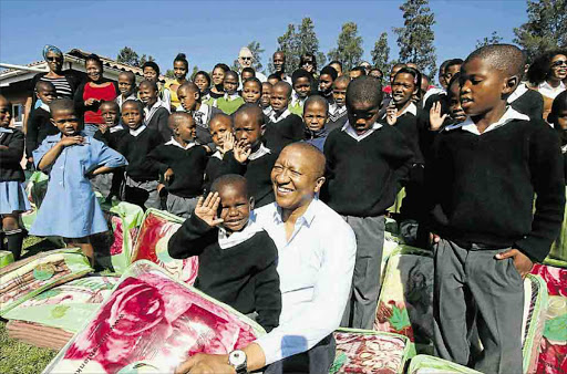 Property magnate Sisa Ngebulana celebrates his 51st birthday by handing over blankets and groceries to needy pupils in Ngqeleni. He also plans to build classrooms and a computer lab at his old school, Ntaphane Junior Secondary School, near Mthatha Picture: LULAMLE FENI